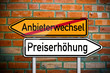 Wegweiser auf Ziegelsteinwand mit Preise und Anbieter