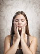 Face with closed eyes of a young woman on a textured background