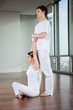 Male Yoga Instructor Assisting Woman