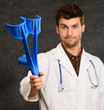 Portrait Of A Young Doctor Holding Crouches