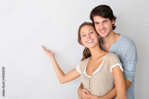 Photo: Young couple on white background designating message Young couple on white background designating message