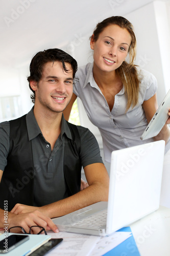Photo: Co-workers in office discussing project Co-workers in office discussing project