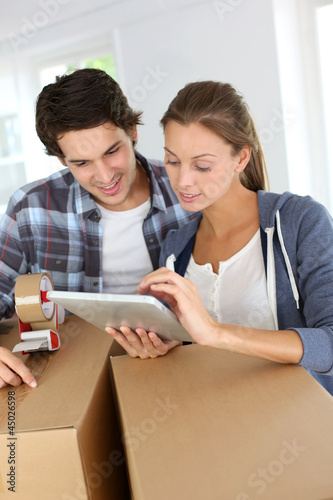 Photo: Couple packing stuff to move in new apartment Couple packing stuff to move in new apartment