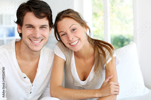 Photo: Portrait of smiling young couple at home Portrait of smiling young couple at home