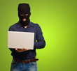 young male thief holding laptop