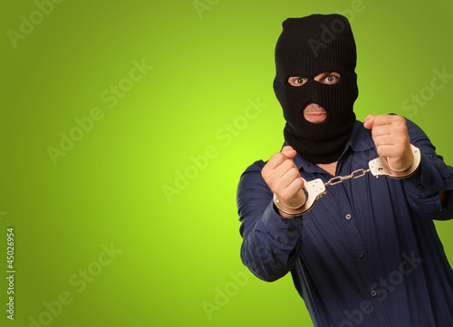 Photo: angry criminal man locked in handcuffs angry criminal man locked in handcuffs