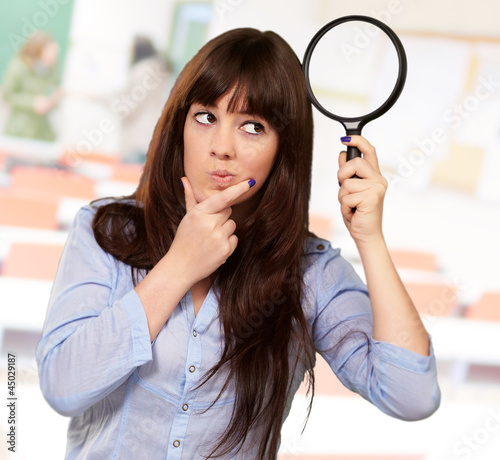 Photo: Portrait Of A Girl Holding A Magnifying Glass And Thinking Portrait Of A Girl Holding A Magnifying Glass And Thinking