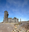 Old abandoned ruined house over blue sky