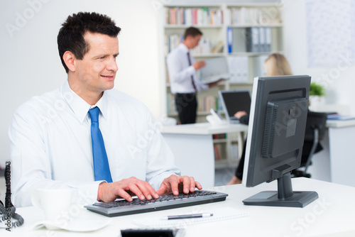 Photo: angestellter arbeitet am pc angestellter arbeitet am pc
