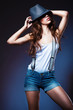 sexy pretty woman in shorts with suspenders in hat
