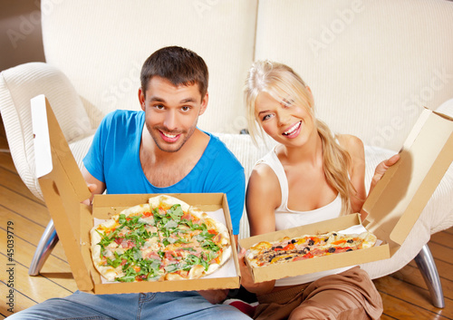 Photo: romantic couple eating pizza at home romantic couple eating pizza at home