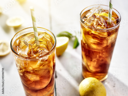 Photo: cold iced tea with straws and lemon slices in summer sun. cold iced tea with straws and lemon slices in summer sun.