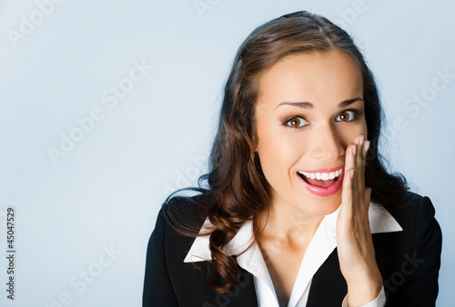 Photo: Business woman covering mouth, over blue Business woman covering mouth, over blue