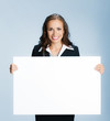 Businesswoman showing signboard, over blue