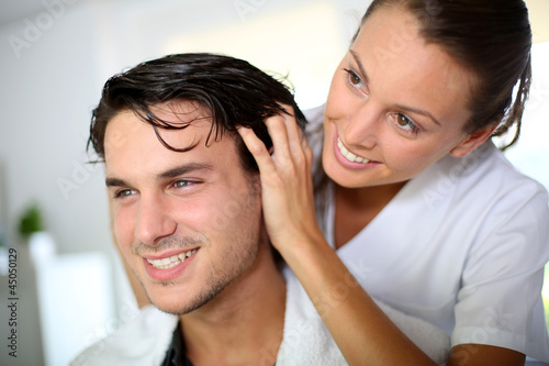 Photo: Hairdresser doing head massage to customer Hairdresser doing head massage to customer