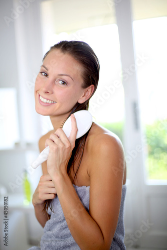 Photo: Portrait of smiling girl brushing her hair Portrait of smiling girl brushing her hair