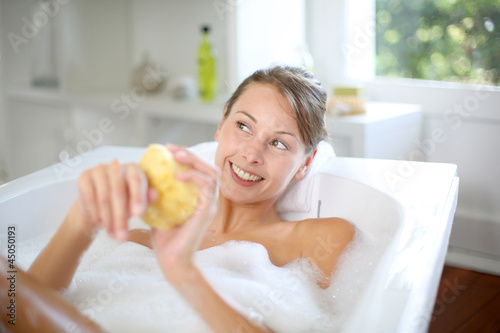 Photo: Beautiful woman using bath sponge Beautiful woman using bath sponge
