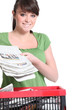 Woman recycling newspaper