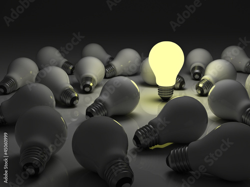 Illustration: One lit light bulb standing out from unlit incandescent bulbs One lit light bulb standing out from unlit incandescent bulbs