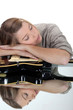 young woman asleep over her guitar