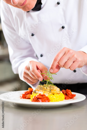 Photo: Köchin in Restaurant oder Hotel Küche beim kochen Köchin in Restaurant oder Hotel Küche beim kochen