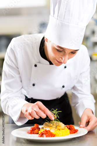 Photo: Köchin in Restaurant oder Hotel Küche beim kochen Köchin in Restaurant oder Hotel Küche beim kochen