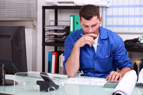 Photo: Manual worker at an office desk Manual worker at an office desk