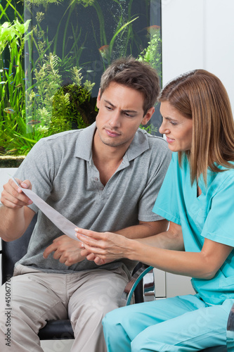 Photo: Dentist And Patient Reading Report Dentist And Patient Reading Report