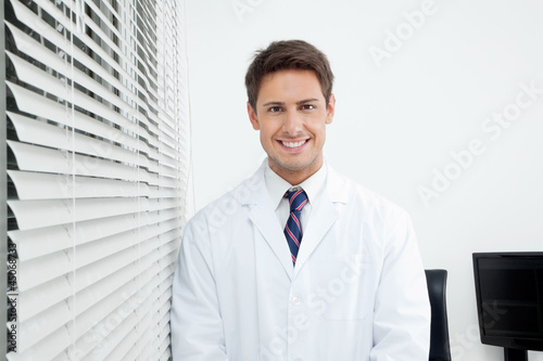 Photo: Happy Dentist Standing In Clinic Happy Dentist Standing In Clinic