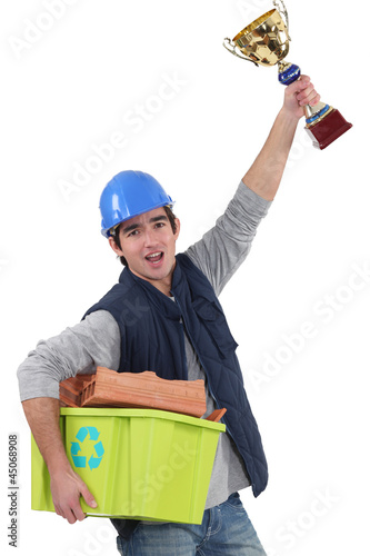 Photo: Builder stood with award for recycling Builder stood with award for recycling