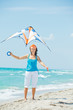 Woman on beach playing with a colorful kite