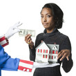 "Mid adult woman holding model house and paying for it, studio shot"