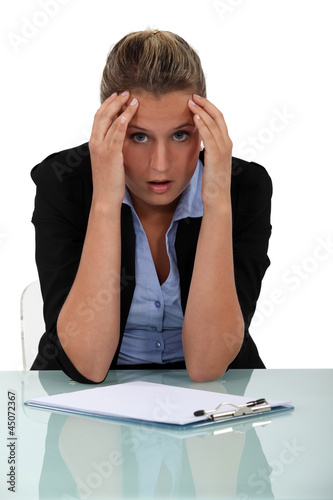 Photo: Shocked employee sitting at her desk Shocked employee sitting at her desk