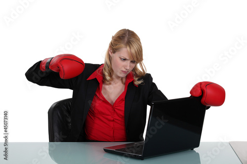 Photo: Woman about to punch her laptop Woman about to punch her laptop