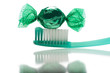 Candy with toothbrush on white background