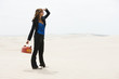 "USA, Utah, Little Sahara, young woman holding kettle in desert"