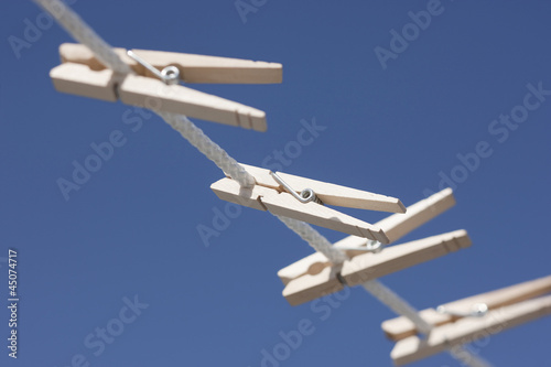 Photo: Clothes pegs hanging on washing line Clothes pegs hanging on washing line