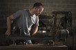 "USA, Utah, Orem, man using machine in workshop"