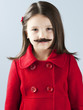 "Girl (6-7) in red coat wearing fake mustache, portrait"