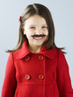 "Girl (6-7) in red and fake mustache smiling, portrait"