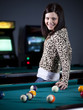 "USA, Utah, American Fork, young woman standing in playroom with pool cue behind her back"