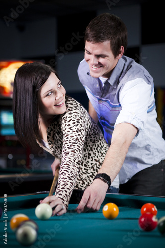 Photo: "USA, Utah, American Fork, young couple playing pool" "USA, Utah, American Fork, young couple playing pool"