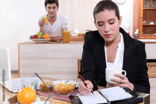 Photo: Couple eating breakfast separately Couple eating breakfast separately