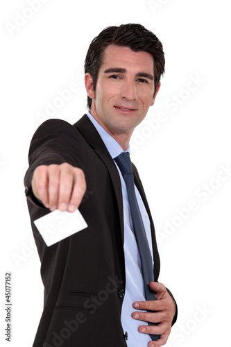 Photo: A businessman handing his business card. A businessman handing his business card.