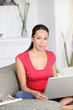 Woman with computer sitting on sofa