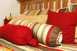 Bed and pillows in red, yellow and green stripes.