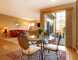 Elegant dining table near large door and living room.