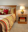 Wood bed and nightstand with stripes in red, yellow and green.