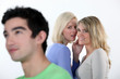 Two girls gossiping about man