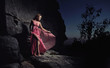Photo: Glamour woman standing next to a rock Glamour woman standing next to a rock